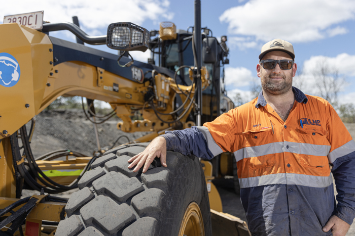 LMP Project Services team member standing by heavy equipment on-site. LMP Project Services team member standing by heavy equipment on-site.